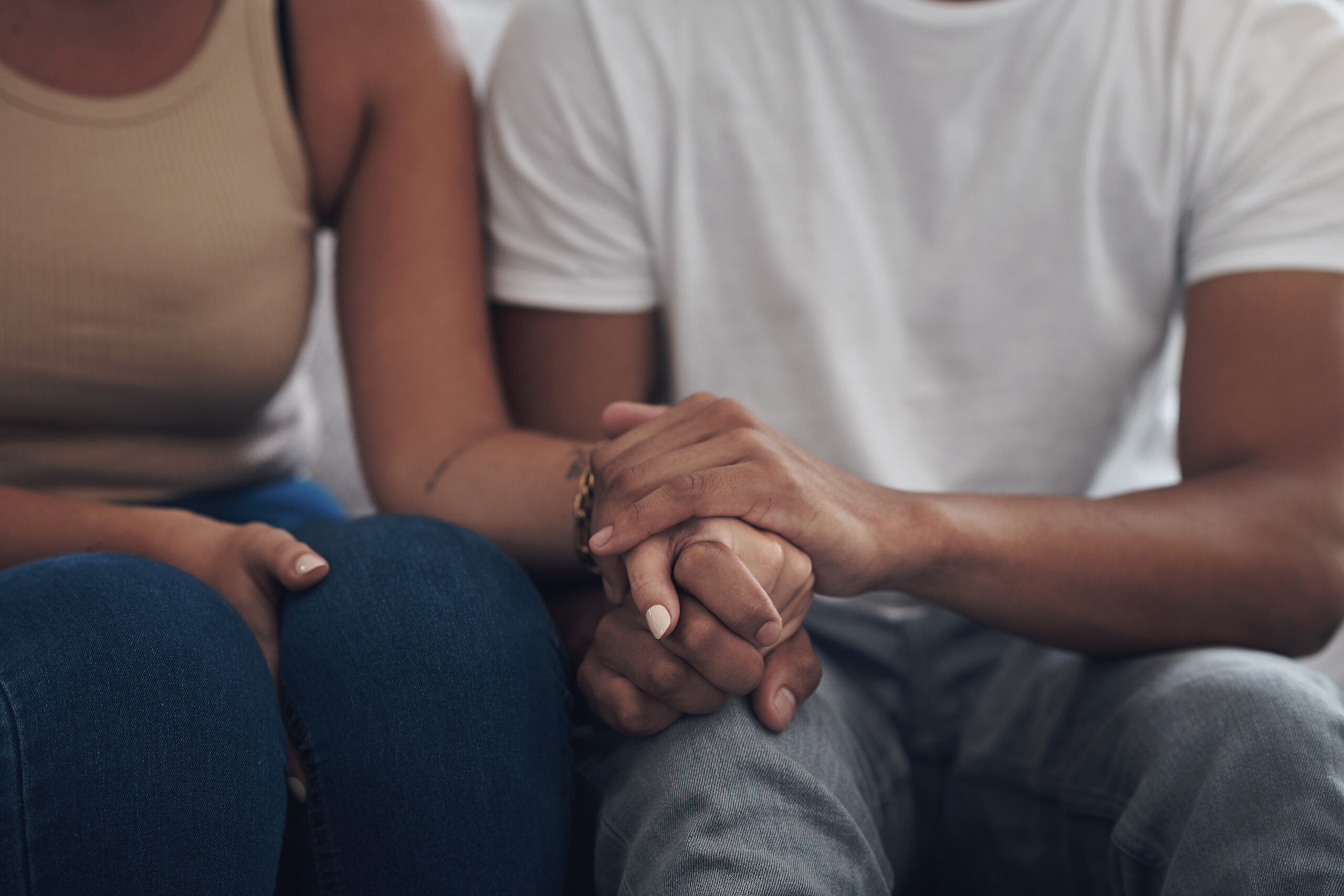Cropped shot of an unrecognizable couple sitting inside together and holding hands
